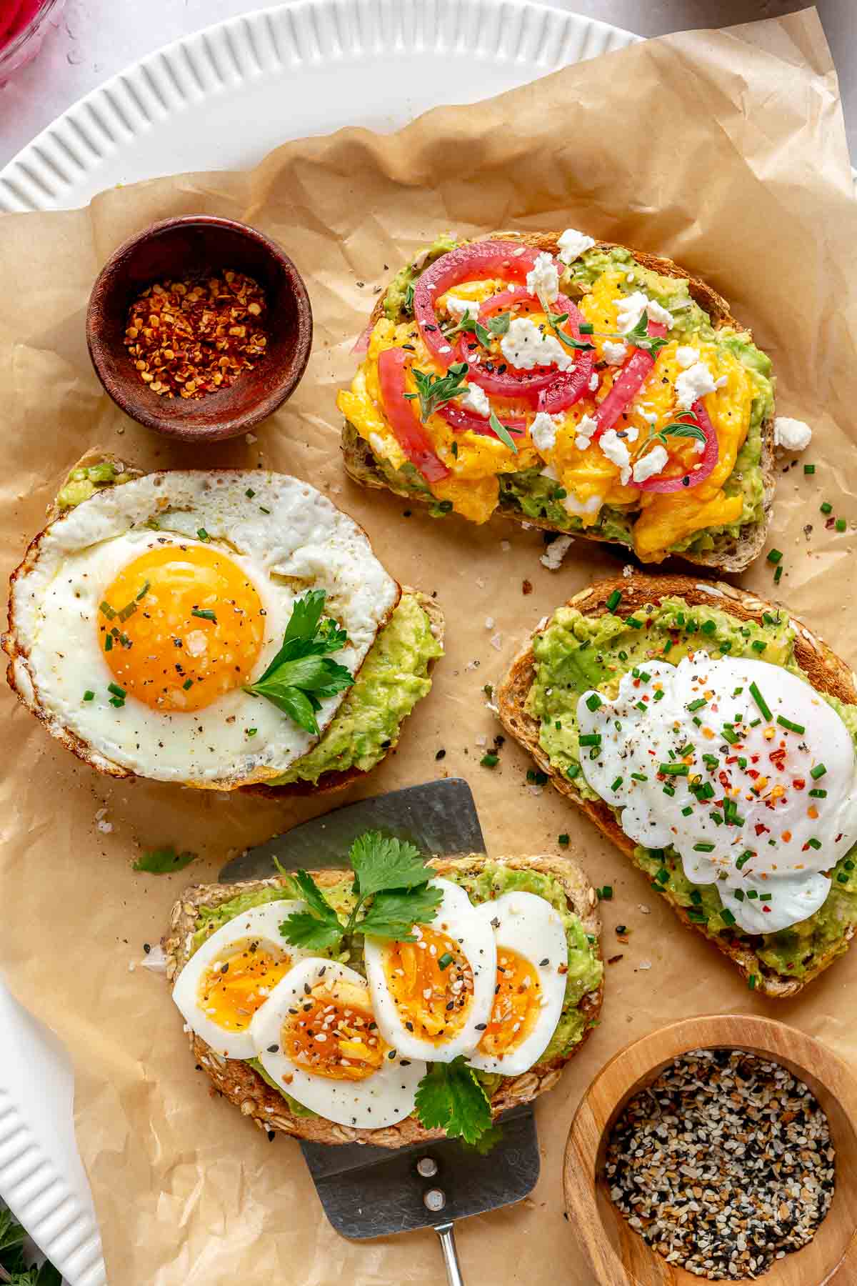 Avocado toast with egg topped with seasonings and pickled red onions.