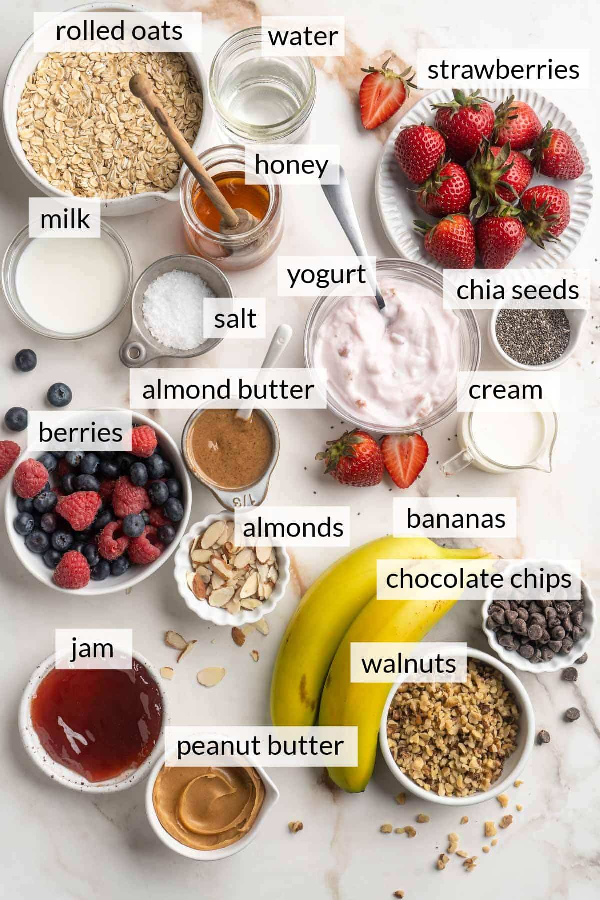 Bowls with rolled oats, berries, milk, peanut butter and various other ingredients for making oatmeal.