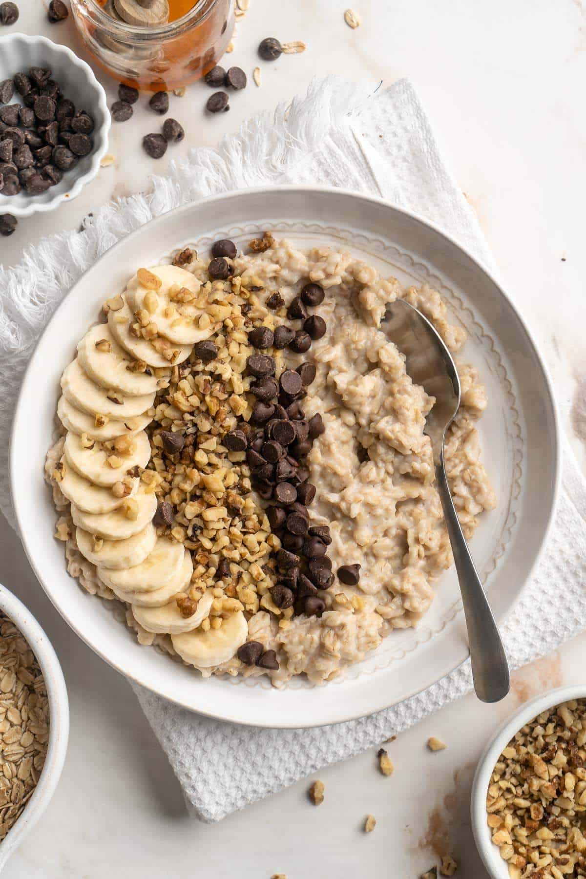 Oatmeal topped with chopped walnuts, mini chocolate chips and banana slices.