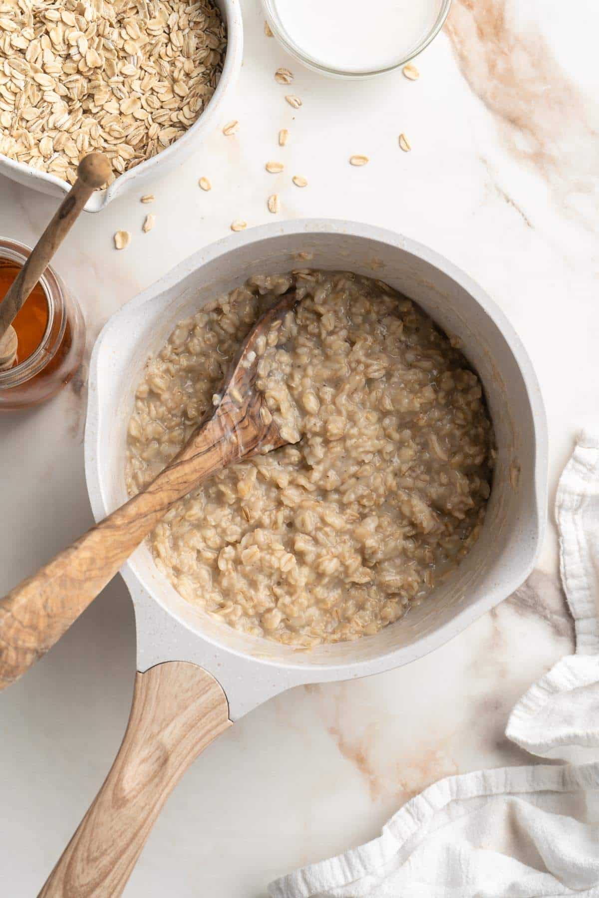 Stirring cooked oatmeal in a pot.