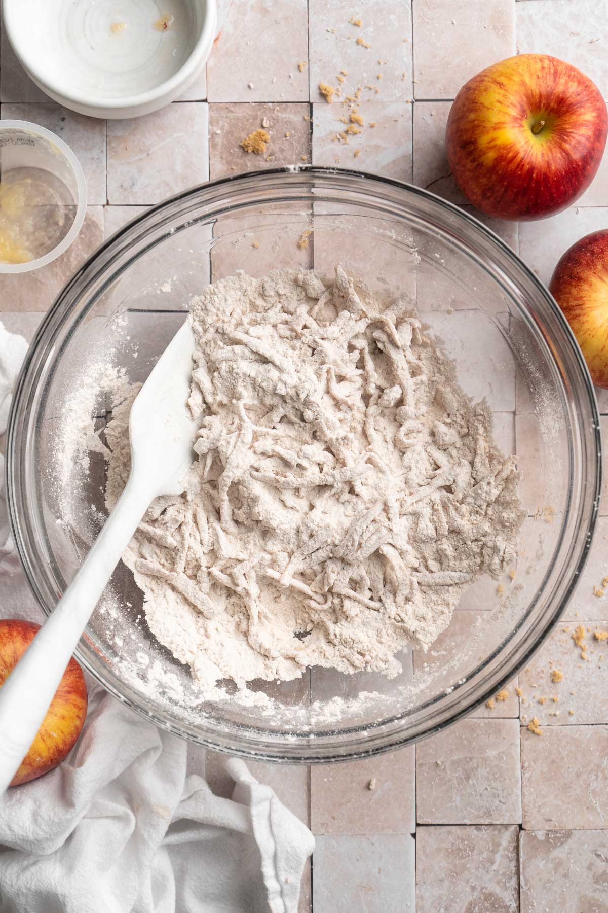 Stirring together flour with spices, baking powder and grated apple in a large bowl.