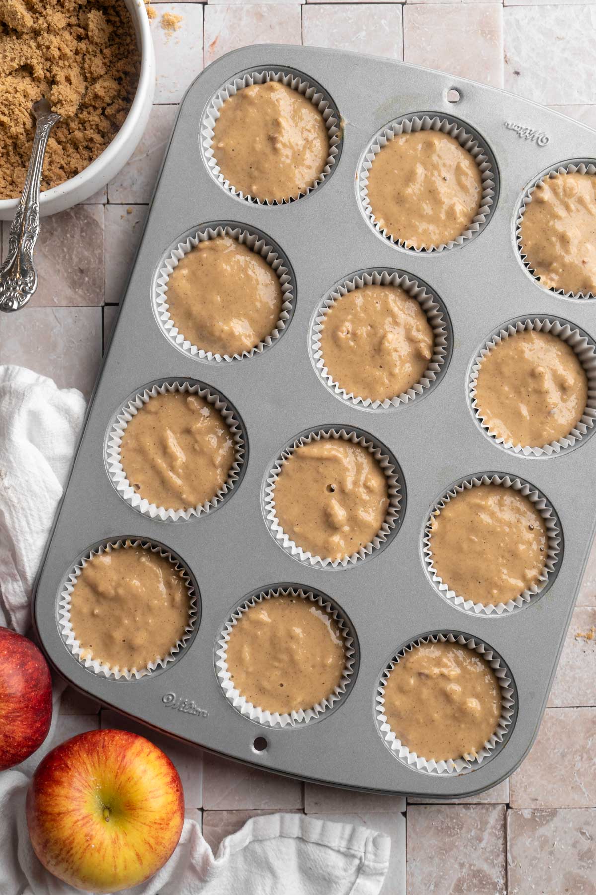 Muffin batter divided in a muffin pan.