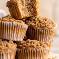 Apple muffins stacked with a bite taken out of one.