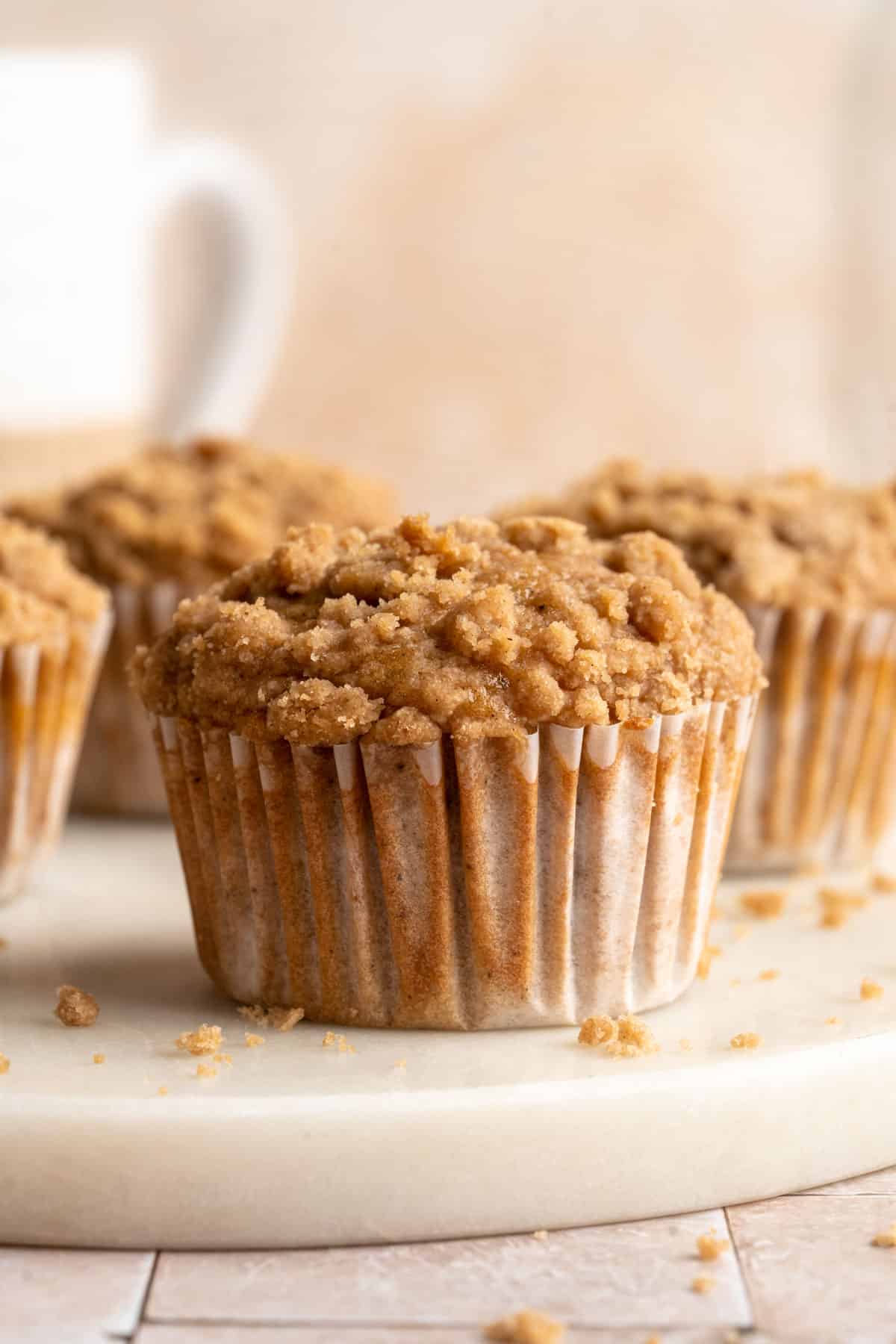 Apple muffins with crumb topping in parchment paper liners.