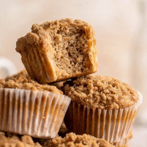 Apple muffins stacked with a bite taken out of one.