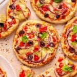 Pita pizzas topped with bell pepper, black olives, red onions and artichokes.