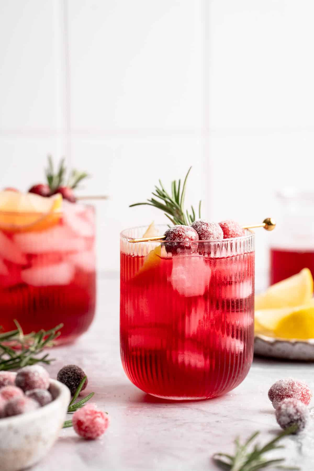 Cranberry drink garnished with cranberries and rosemary.