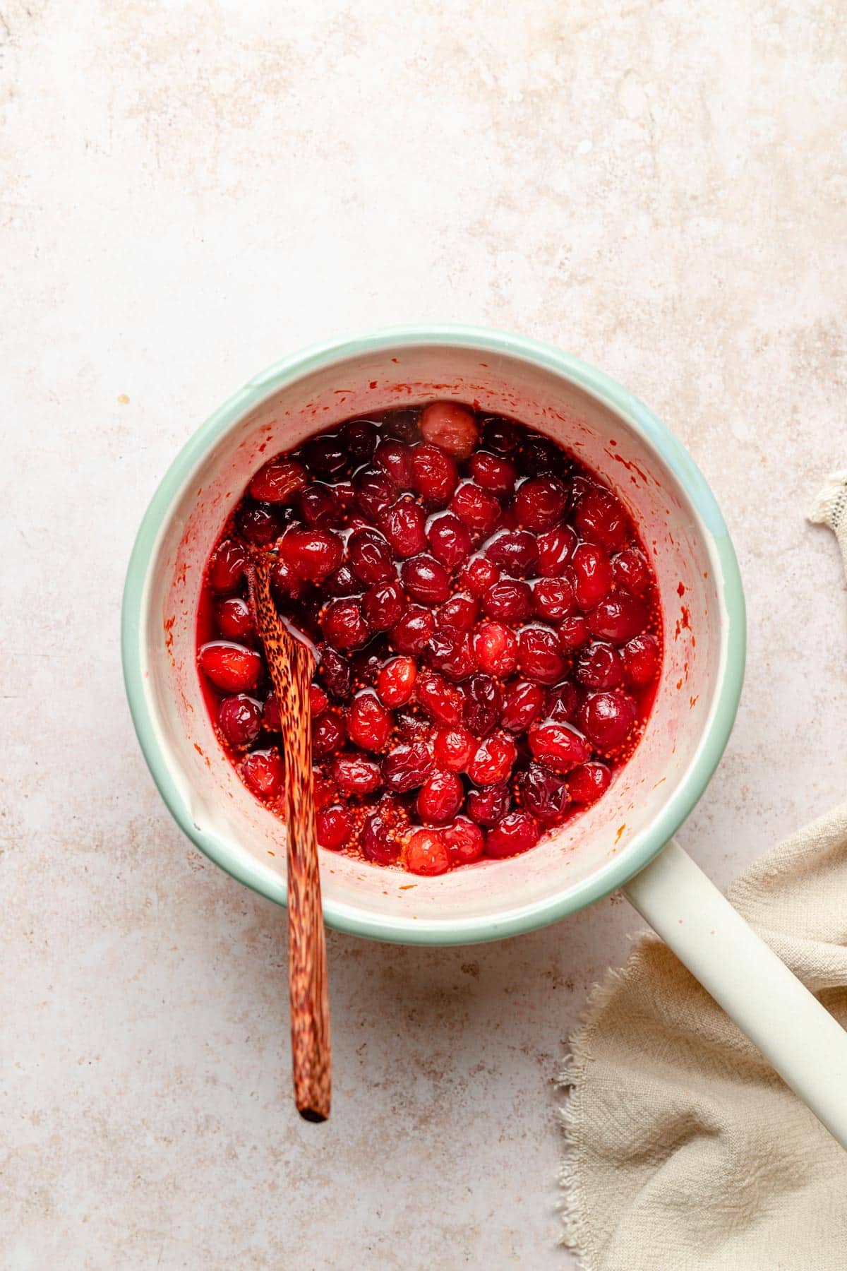 Cooking cranberries in a small pot.