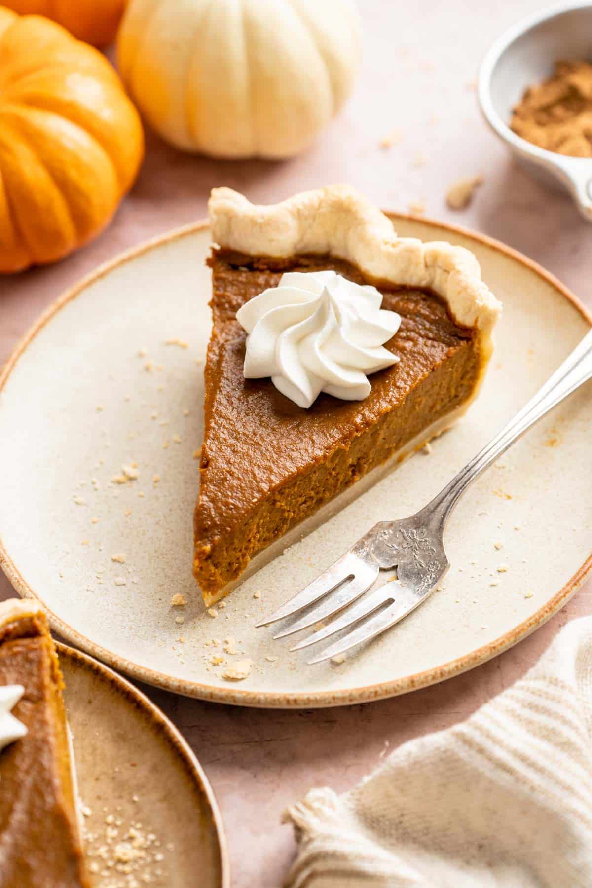 Slice of healthy pumpkin pie on a plate with a fork.