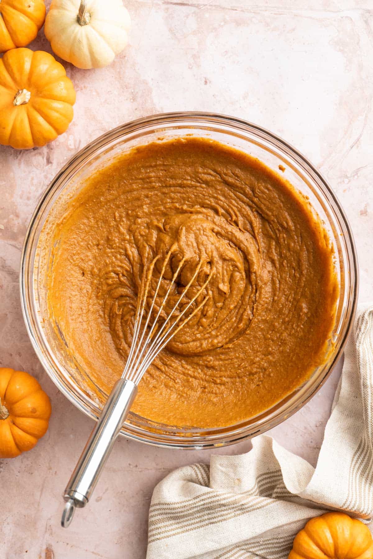 Whisking pumpkin puree with coconut cream and coconut sugar.