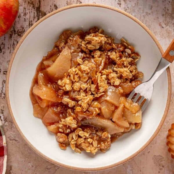 Apple crisp served in a bowl with a fork.