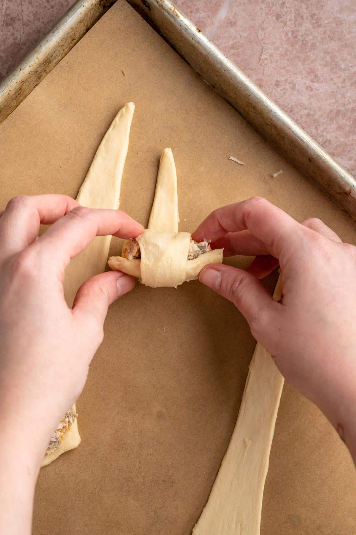 Rolling dough stuffed with cheese mixture.