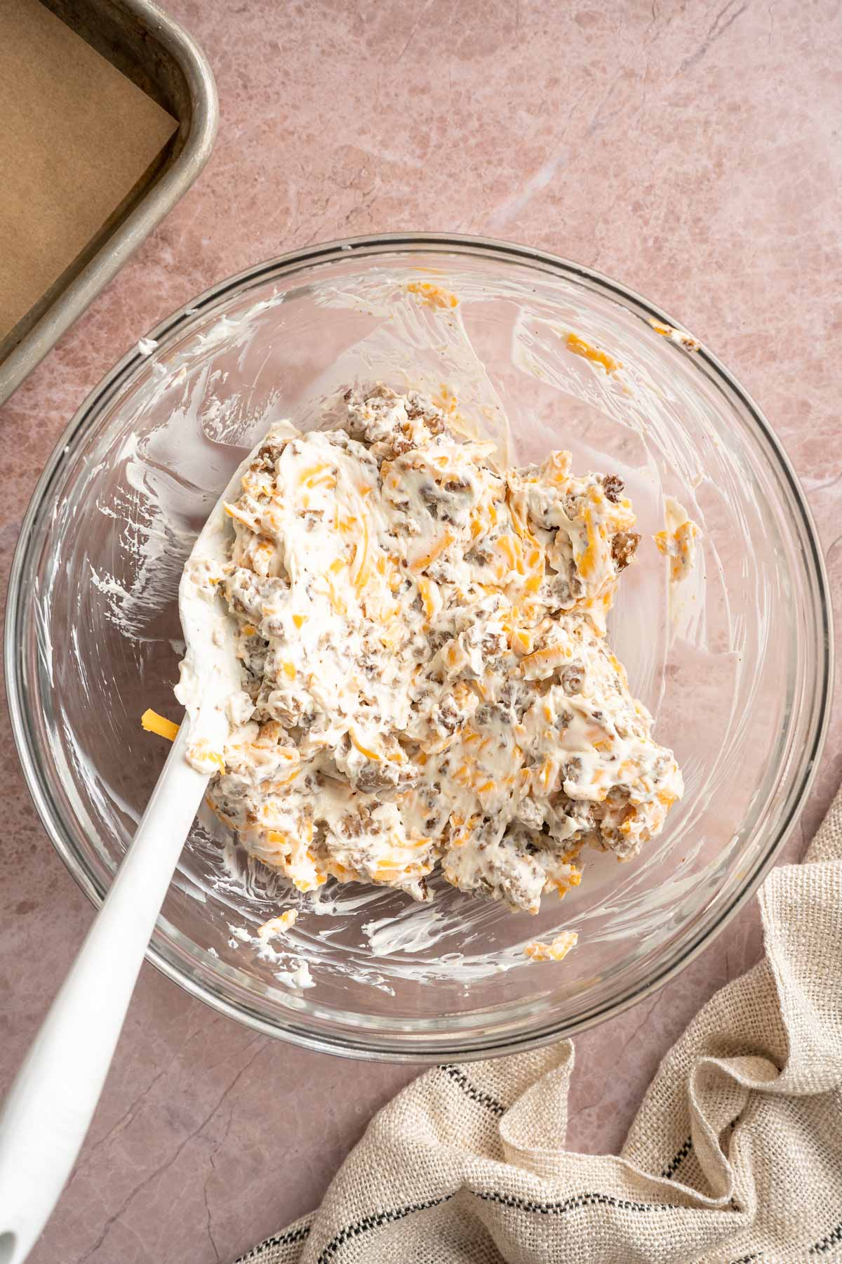 Stirring together cream cheese, shredded cheese and sausage in a large bowl.