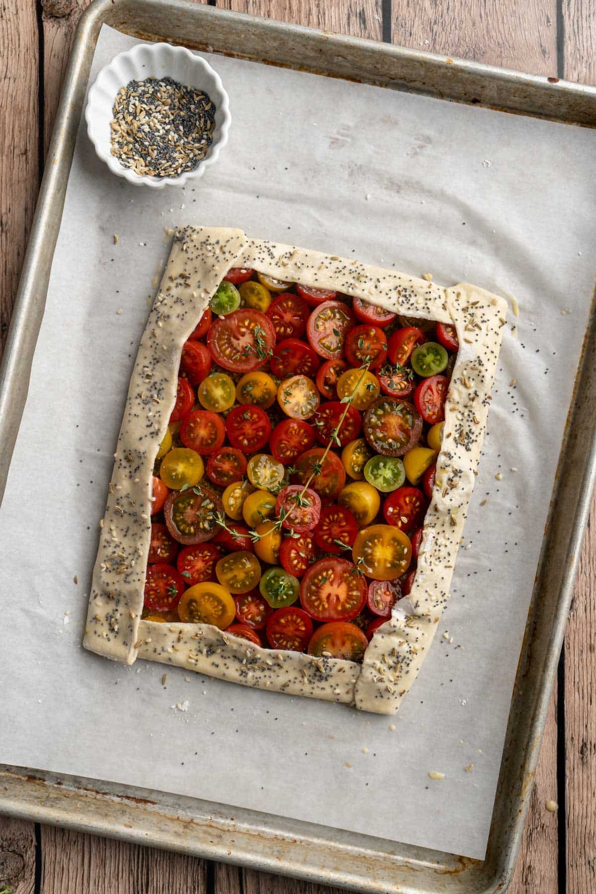 Tomato tart before baking on a sheet pan.