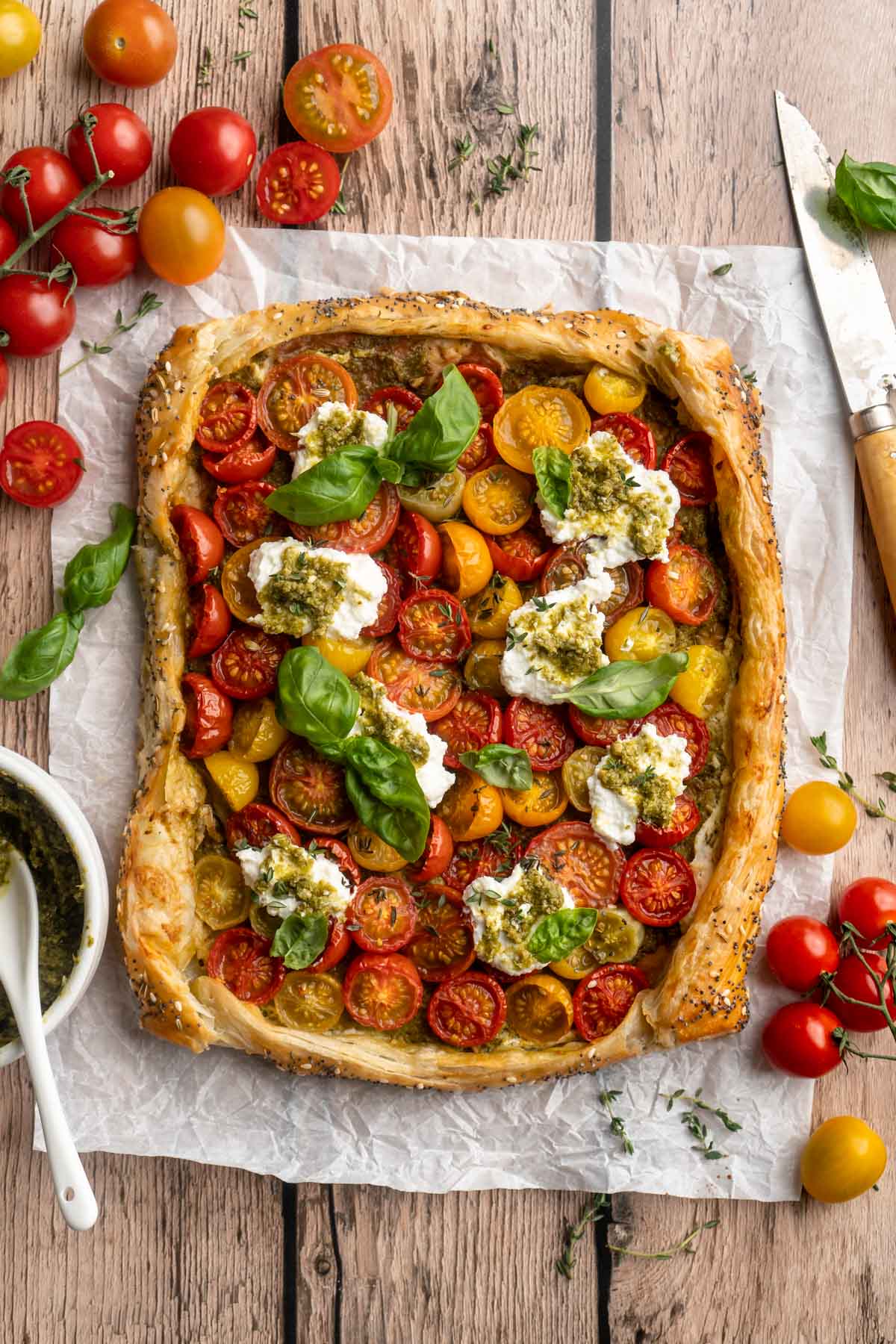 Baked tomato tart topped with ricotta and fresh basil leaves.