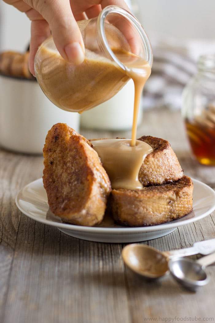 stacked French toast with hand pouring a sauce over the top