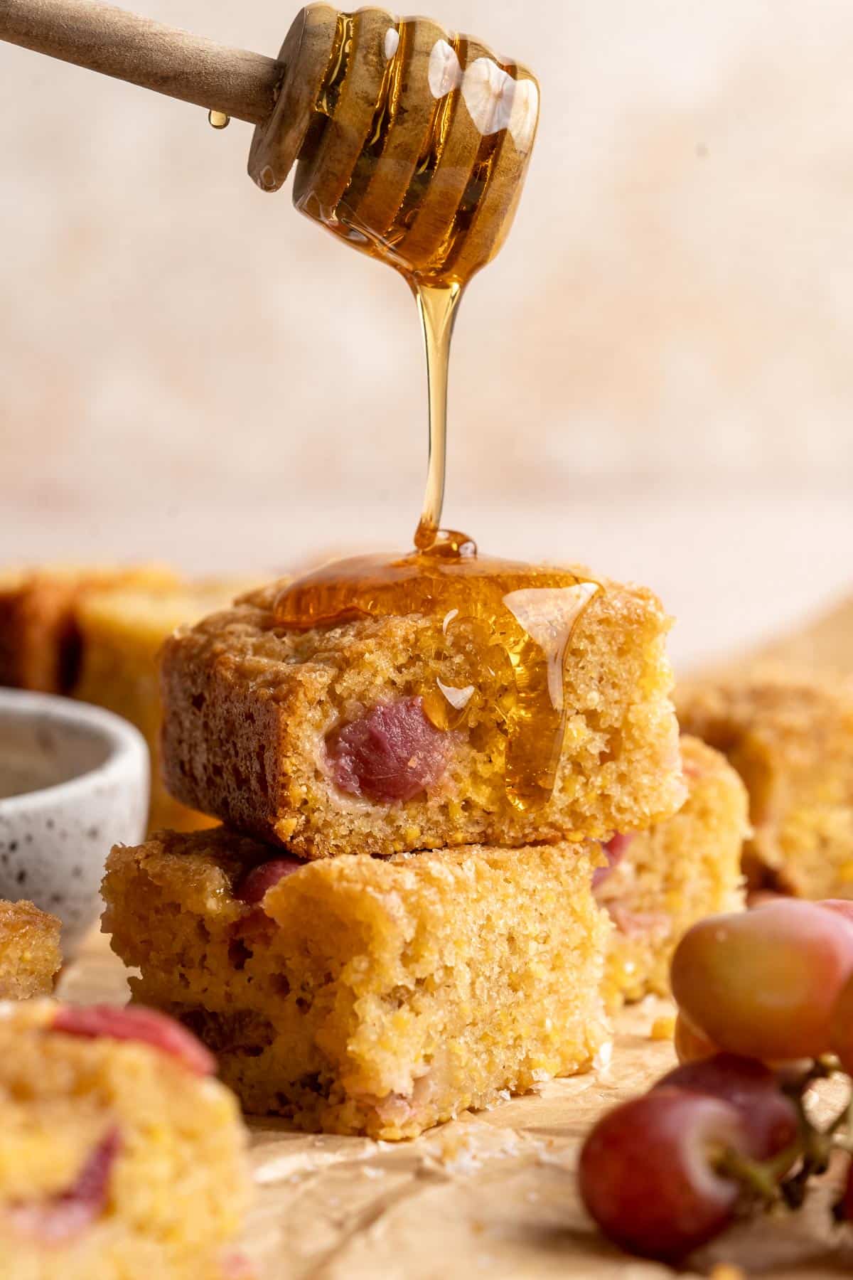 Two pieces of grape cake stacked with a drizzle of honey.