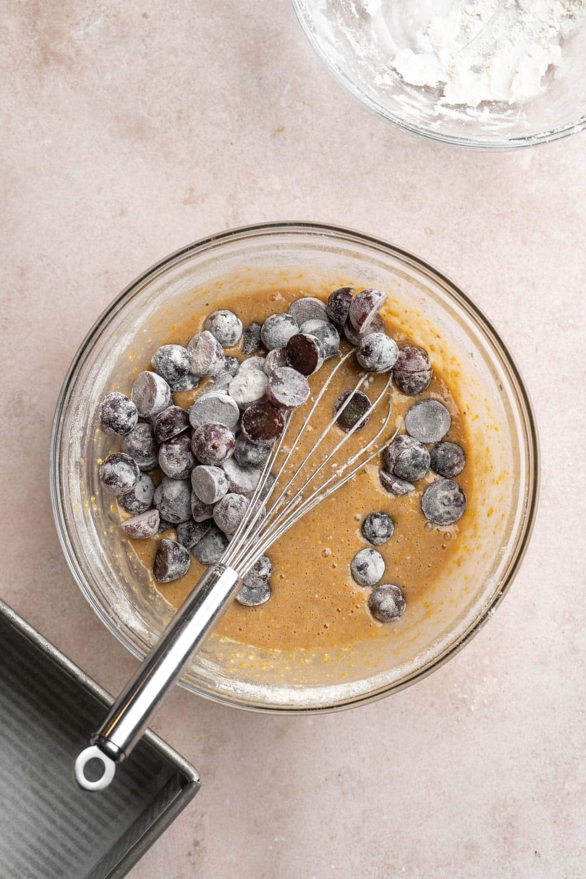 Stirring floured grapes into cake batter.