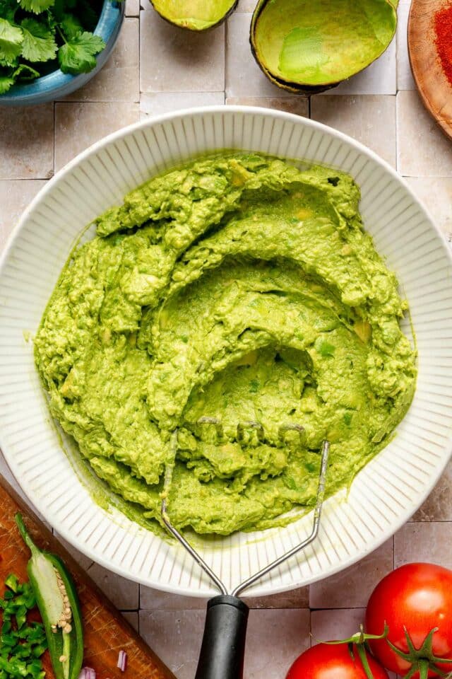 Mashed avocado in a white bowl.