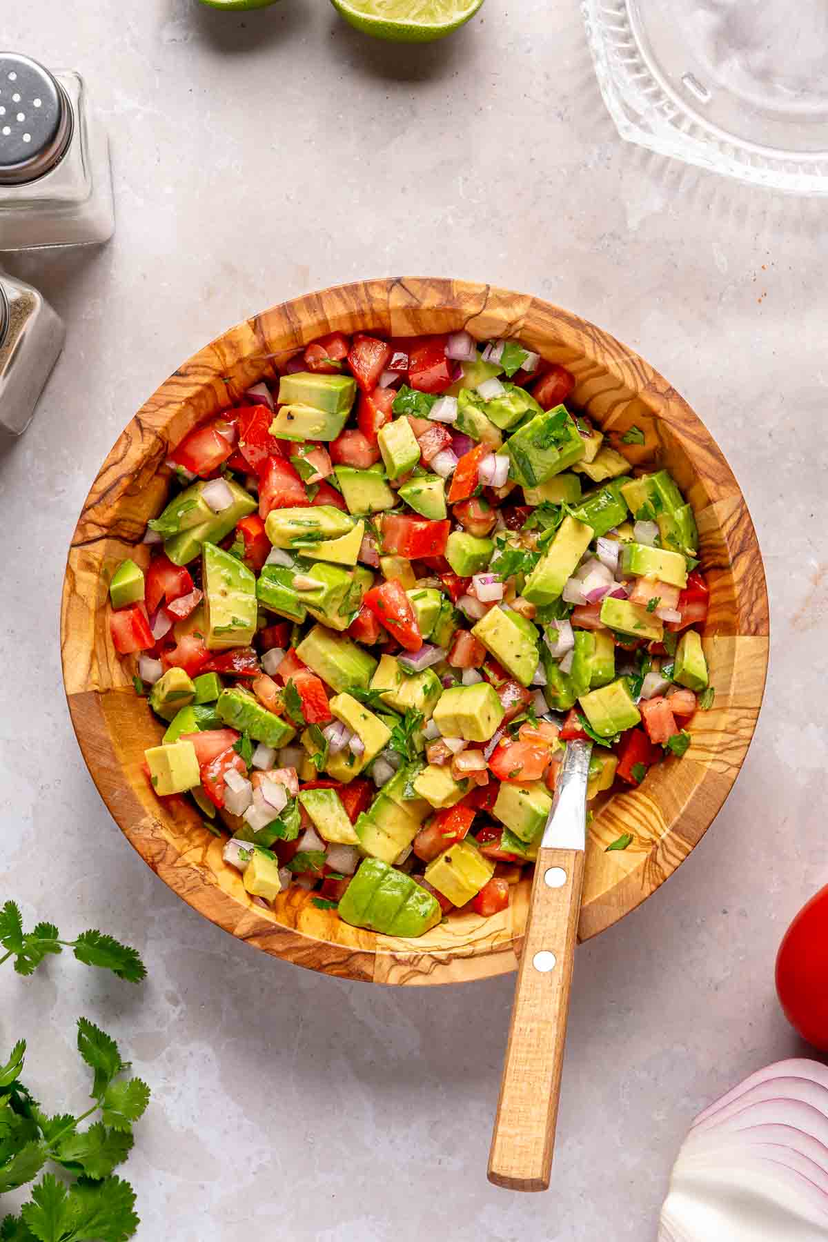 Avocado and tomato salsa stirred in a small bowl.