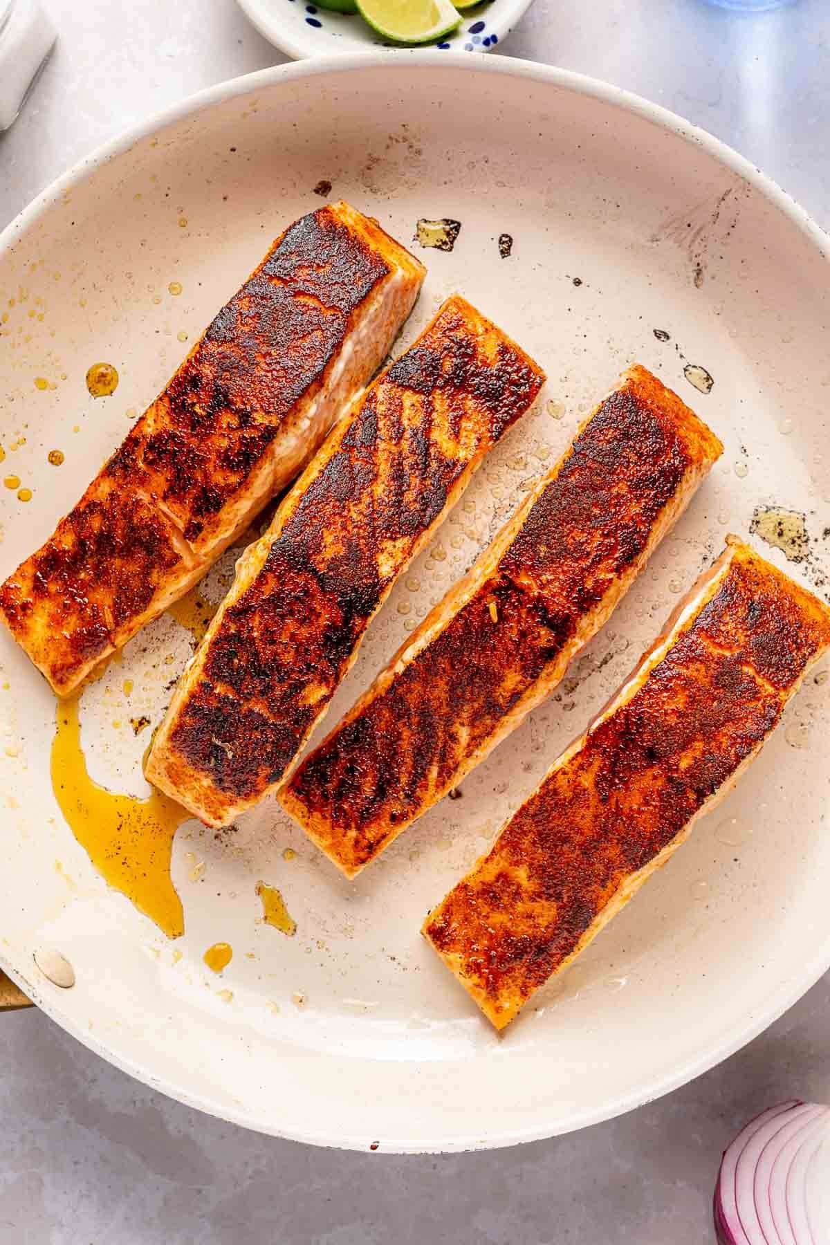 Salmon cooking in a large skillet.