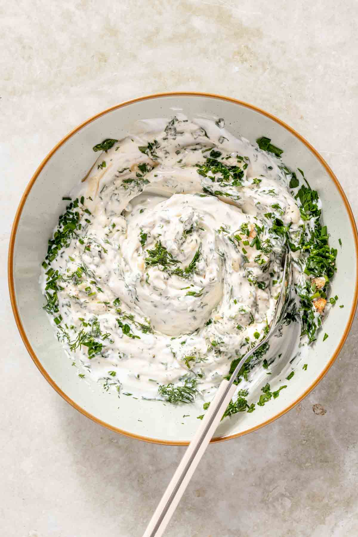 Stirring herbs into ranch dip.