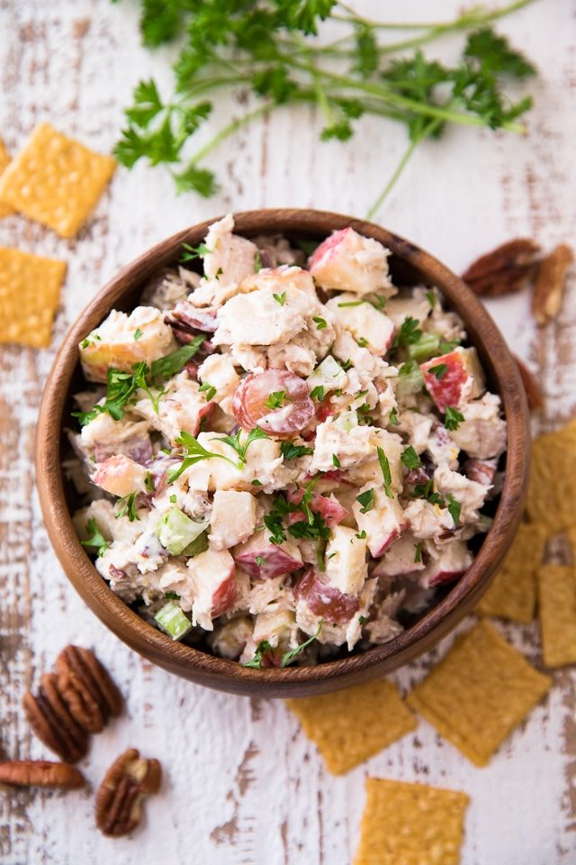 Waldorf Tuna Salad in a wooden serving bowl with crackers scattered around