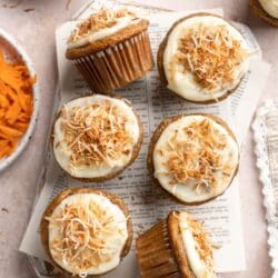 Carrot banana muffins topped with icing and toasted coconut.