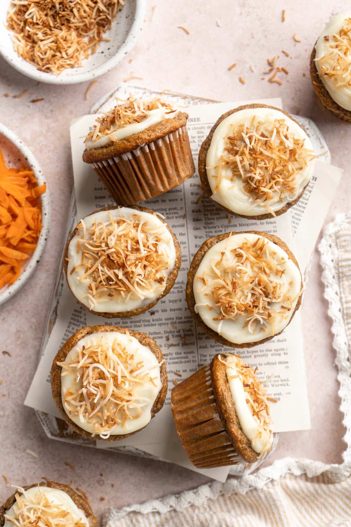 Carrot banana muffins topped with icing and toasted coconut.