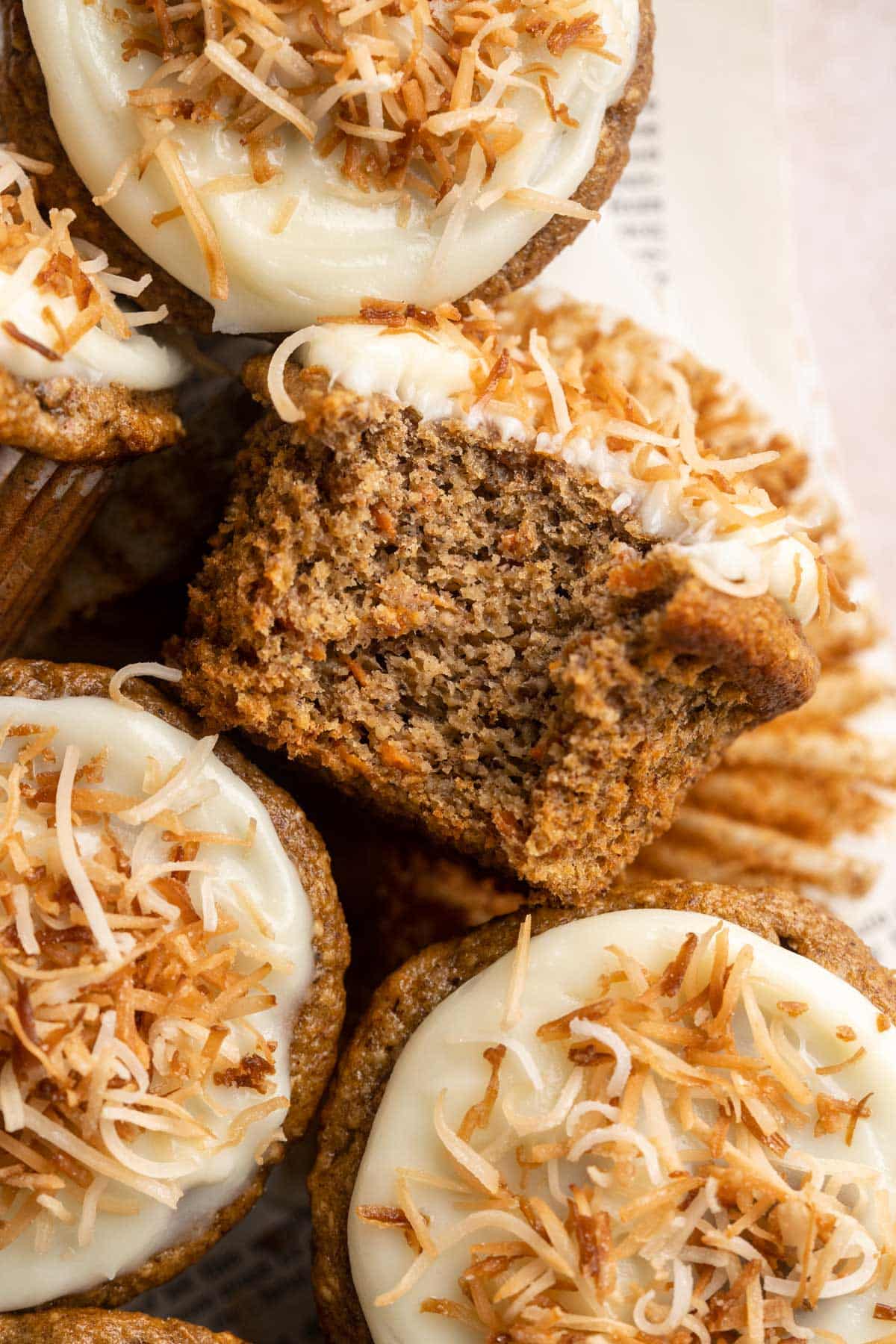 Muffin with icing that has a bite taken out of it.