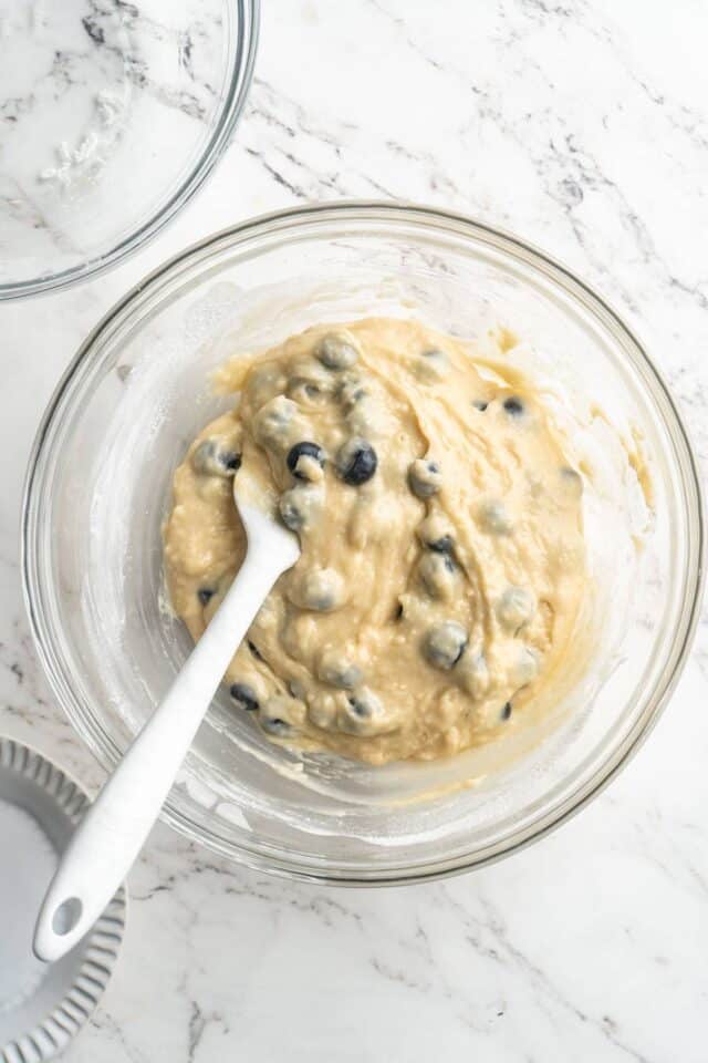 Folding blueberries into muffin batter.