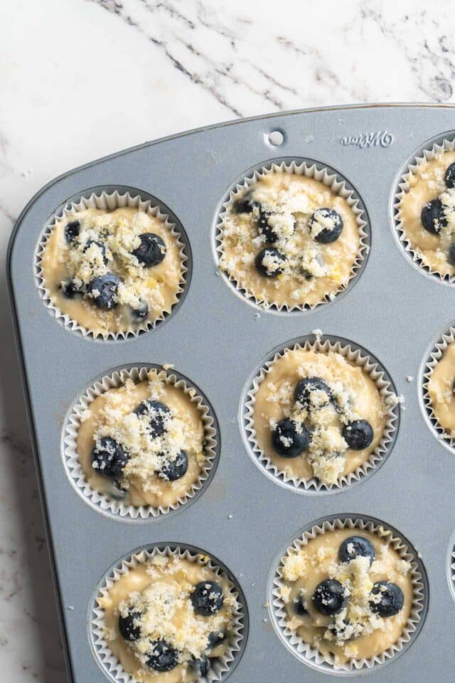 Blueberry muffin batter in a pan topped with lemon zest.