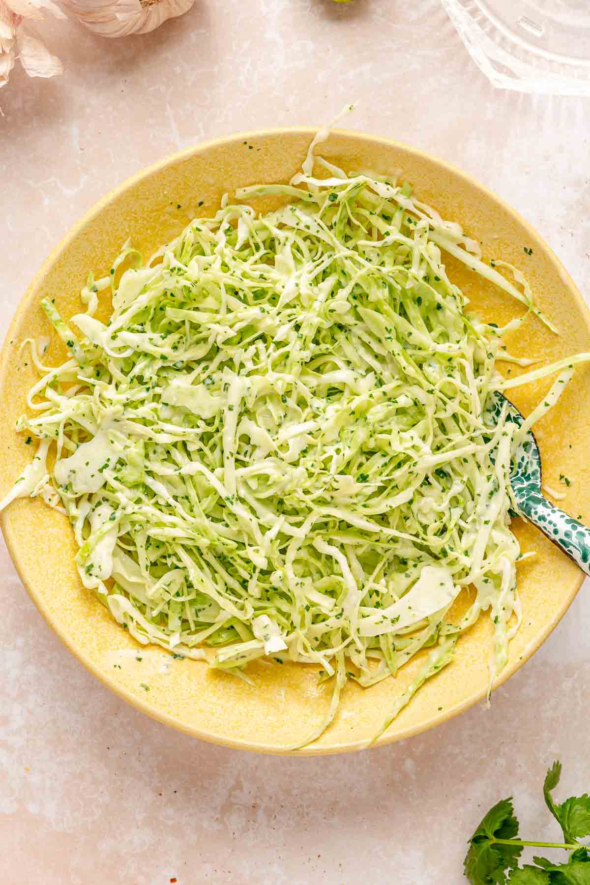 Tossing green cabbage slaw with a cilantro lime cream sauce.