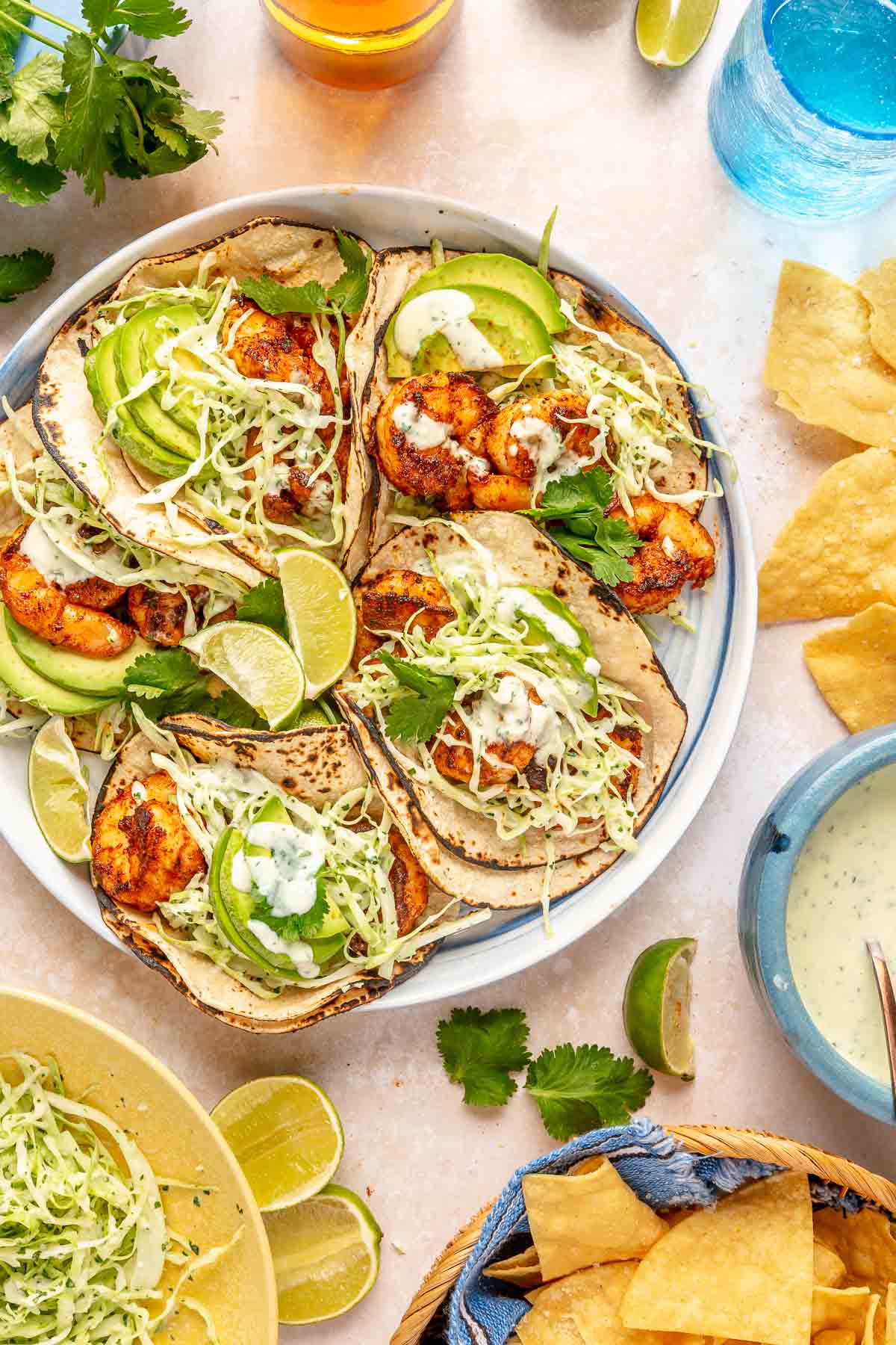 Shrimp tacos served with slaw, cilantro lime sauce and sliced avocados.