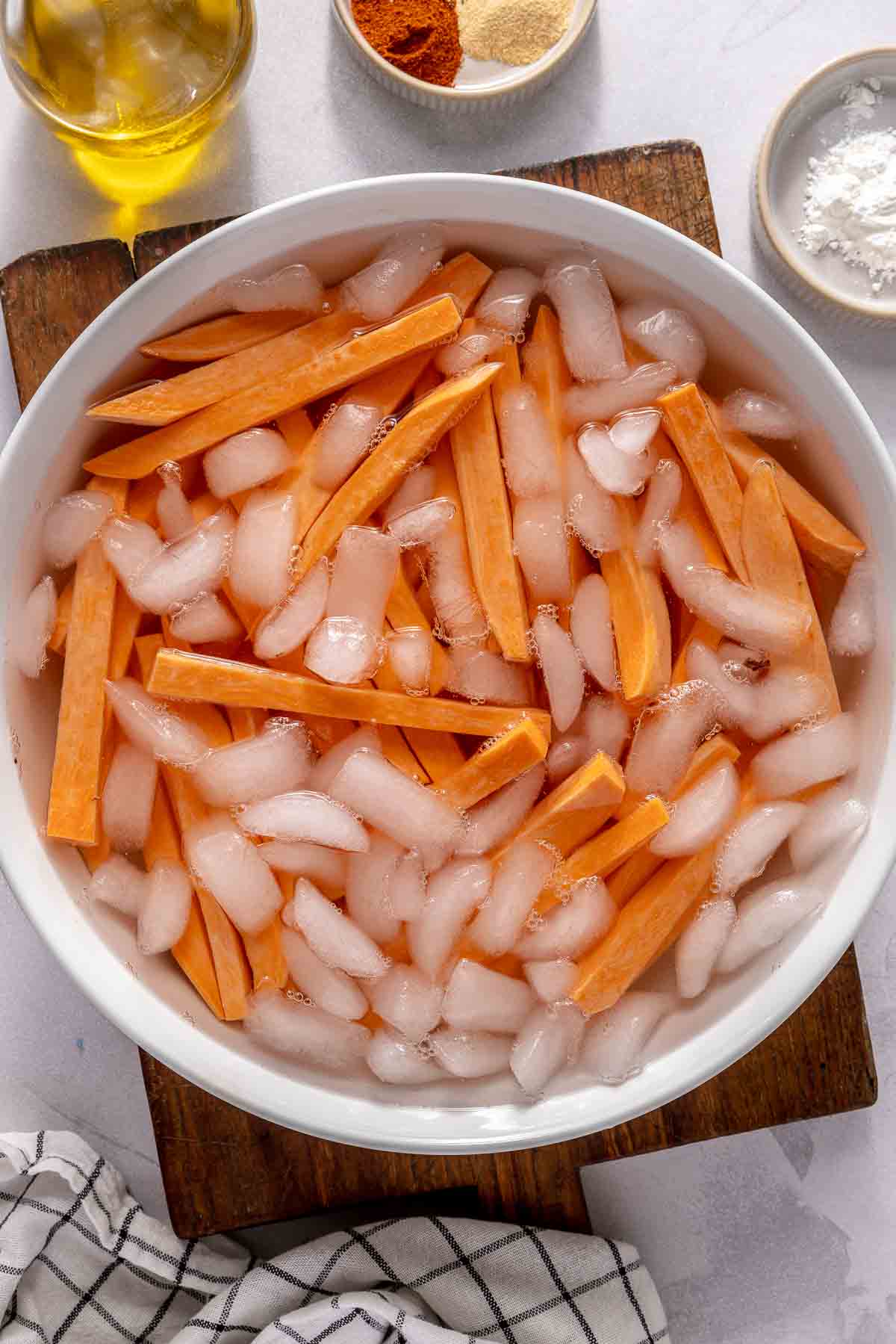 Sliced pieces of sweet potato soaking in ice water.