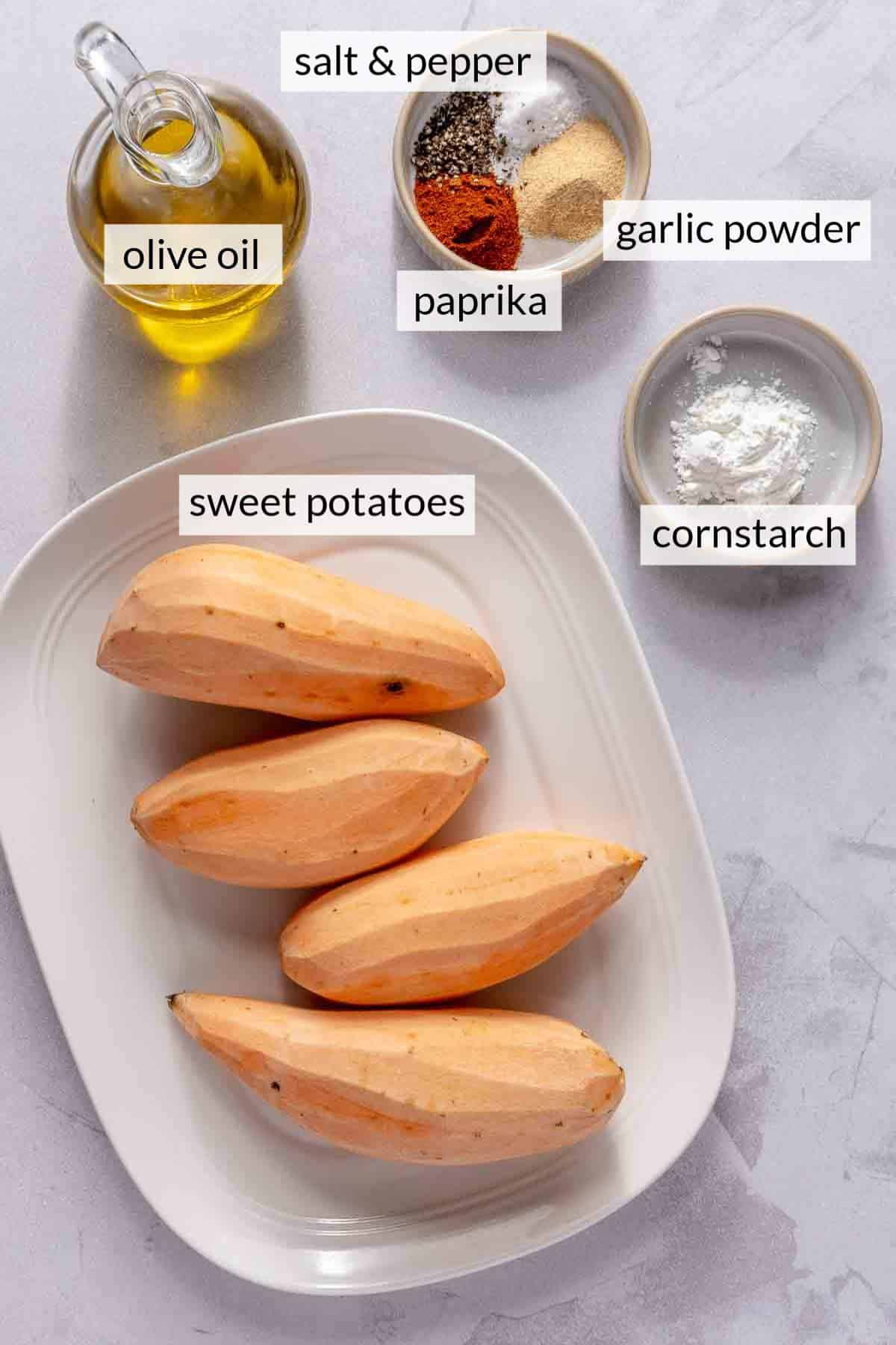 Sweet potatoes on a plate near olive oil and spices.