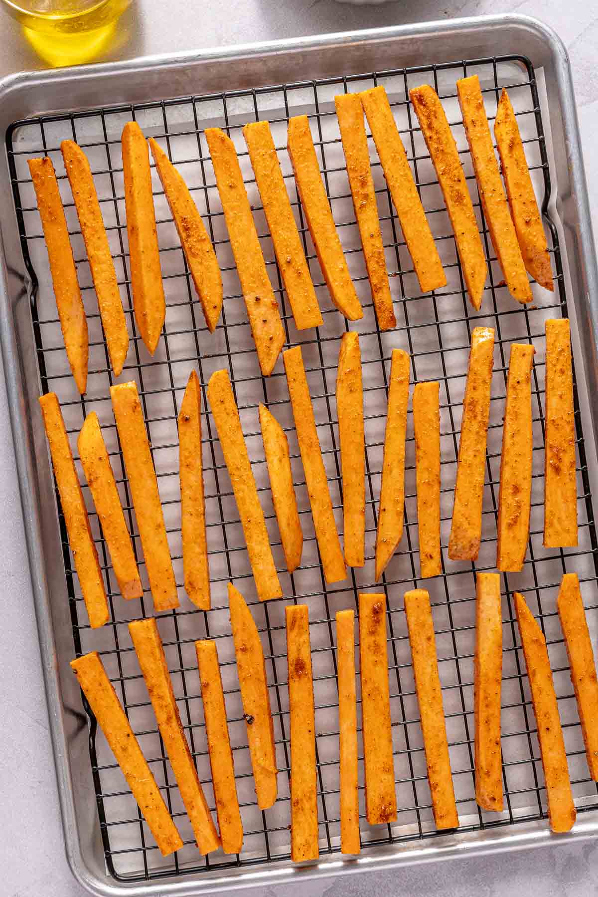 Uncooked sweet potato fries on a baking sheet.