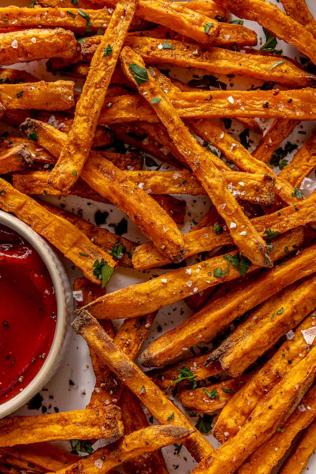 Sweet potato fries on a plate with ketchup.