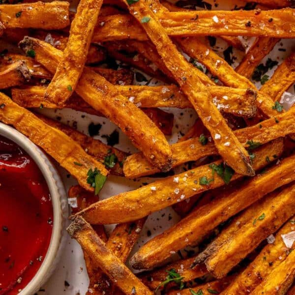 Sweet potato fries on a plate with ketchup.