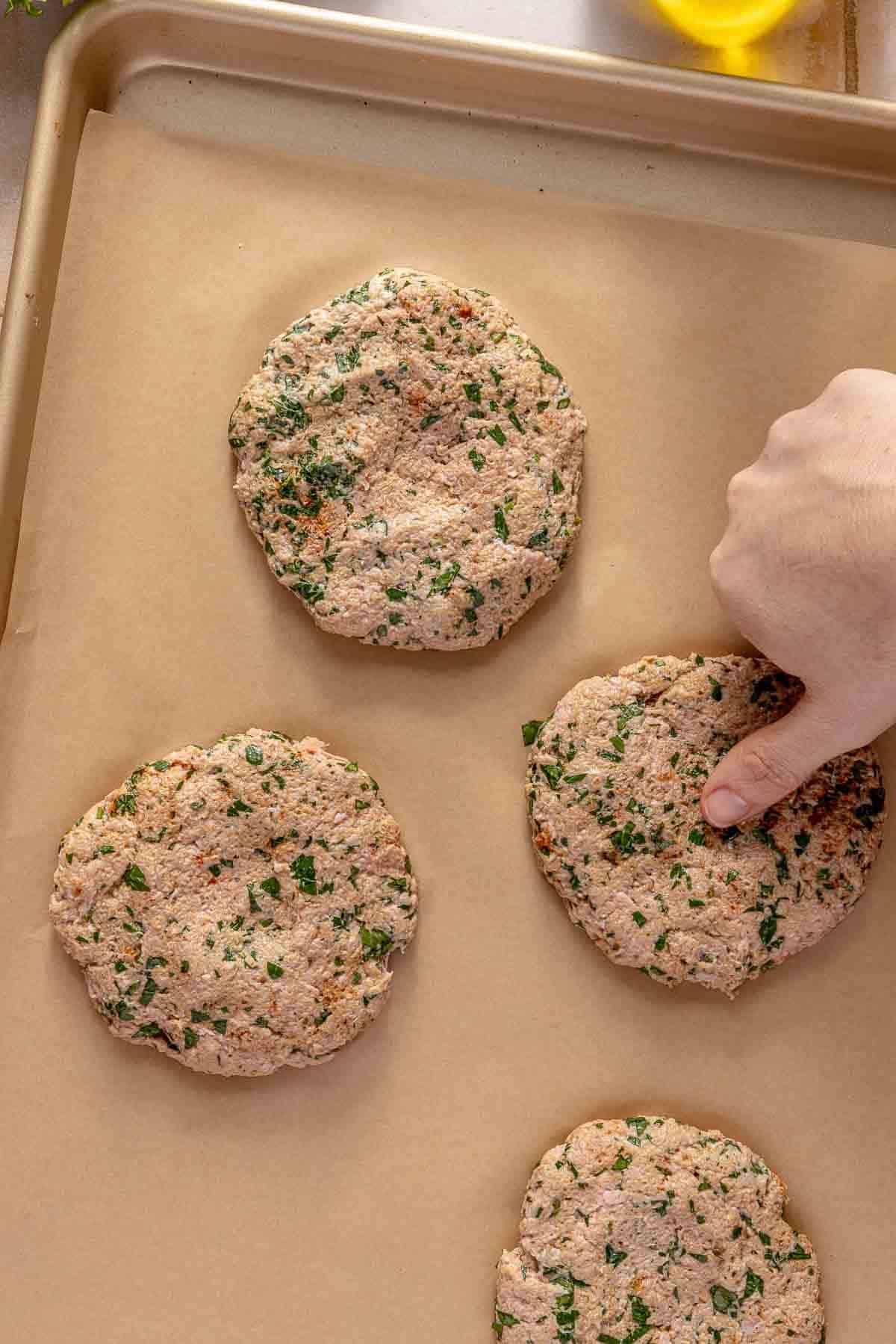 Pressing an indentation into turkey patties.