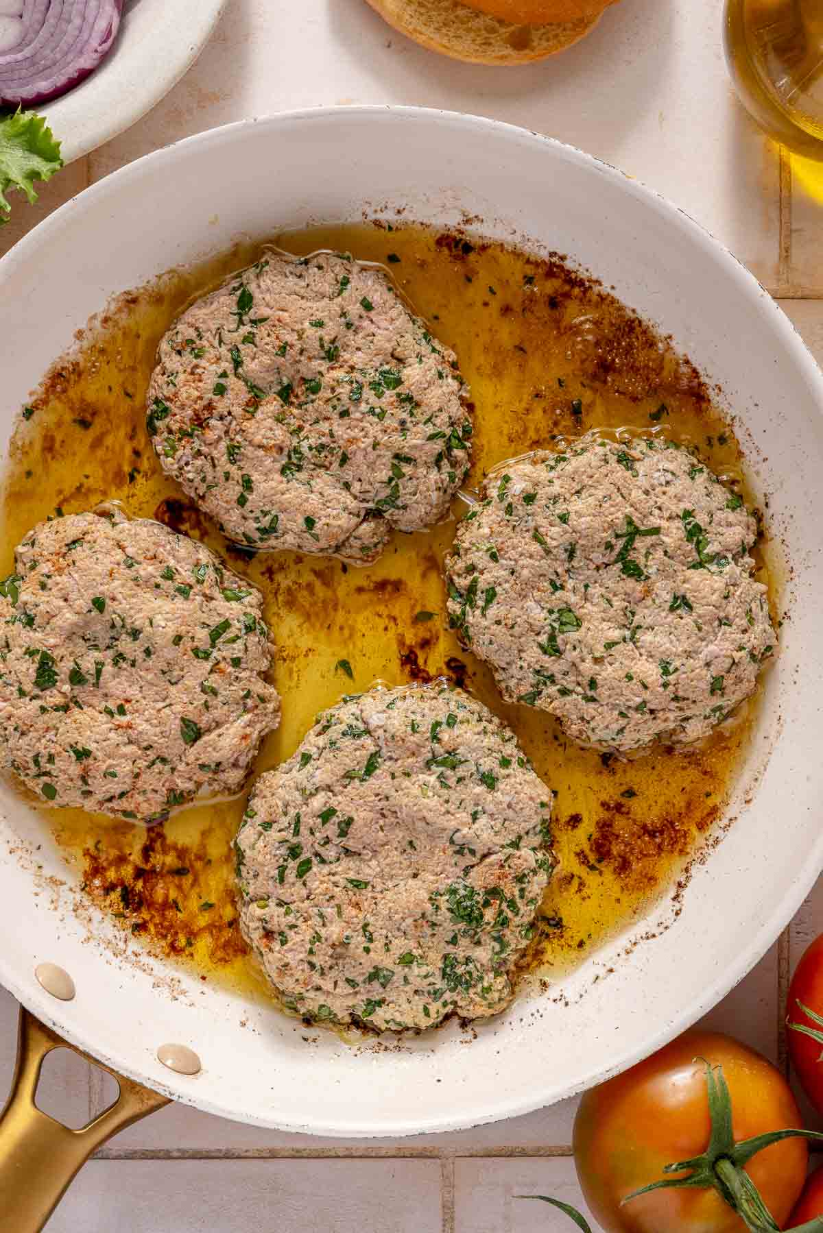 Cooking turkey patties in olive oil in a skillet.