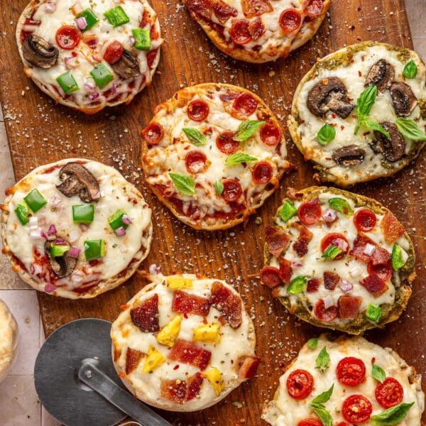 English muffin pizzas topped with pepperonis and veggies.