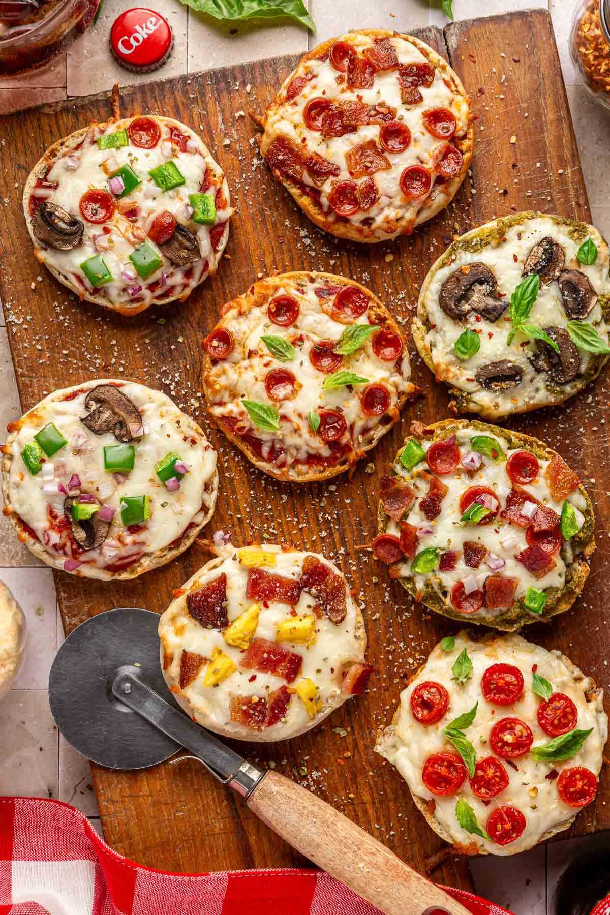 English muffin pizzas topped with pepperonis and veggies.