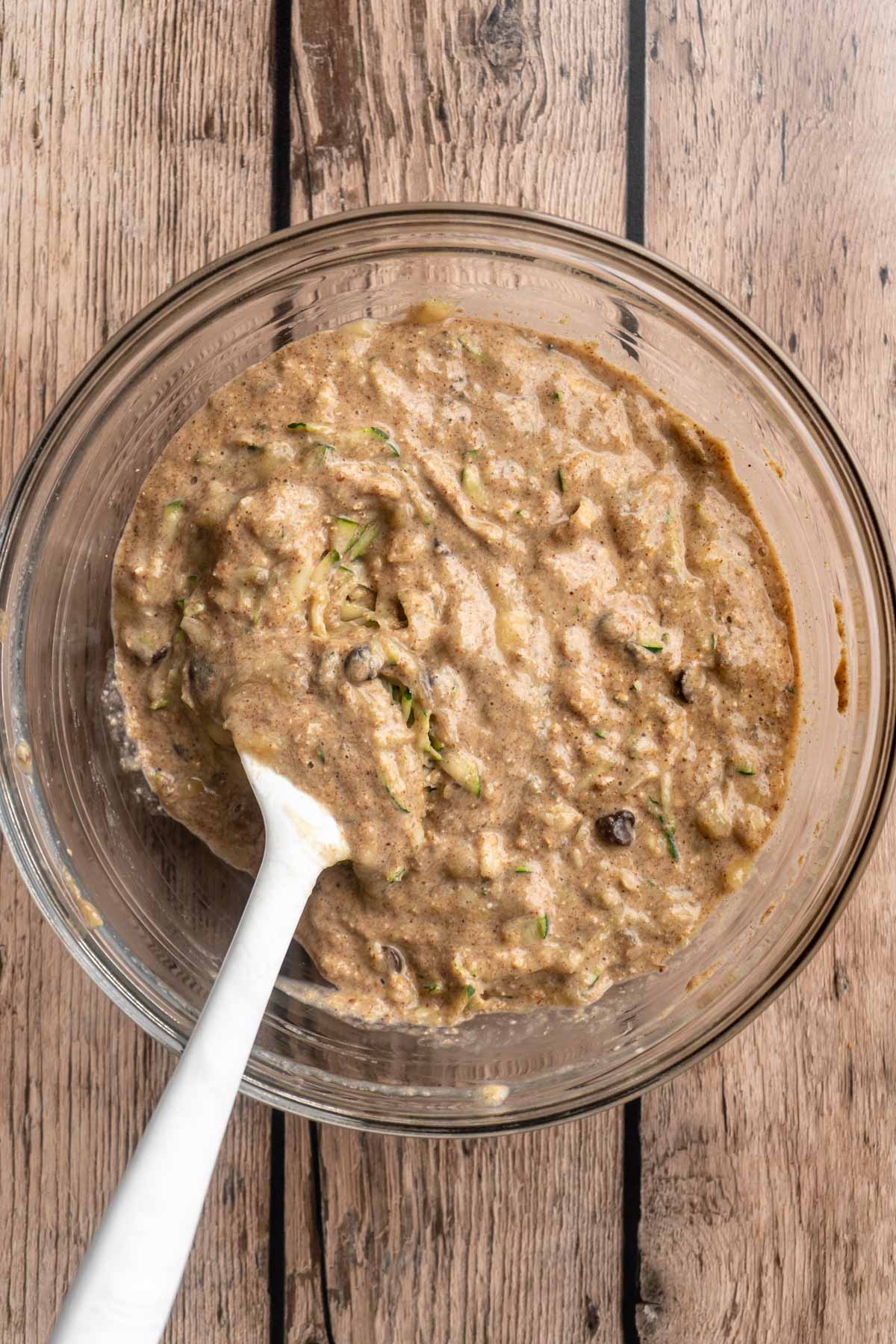 Muffin batter with zucchini and chocolate chips in a large bowl.