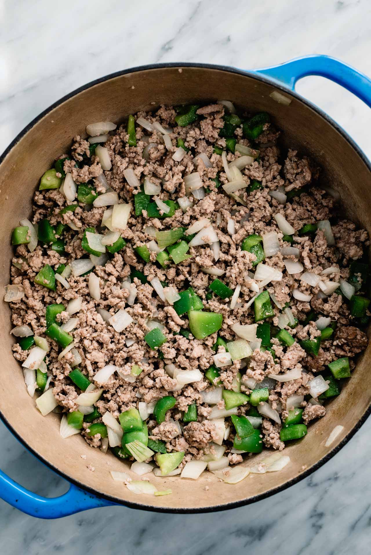 Browning ground beef with onions and bell pepper in a large stock pot.