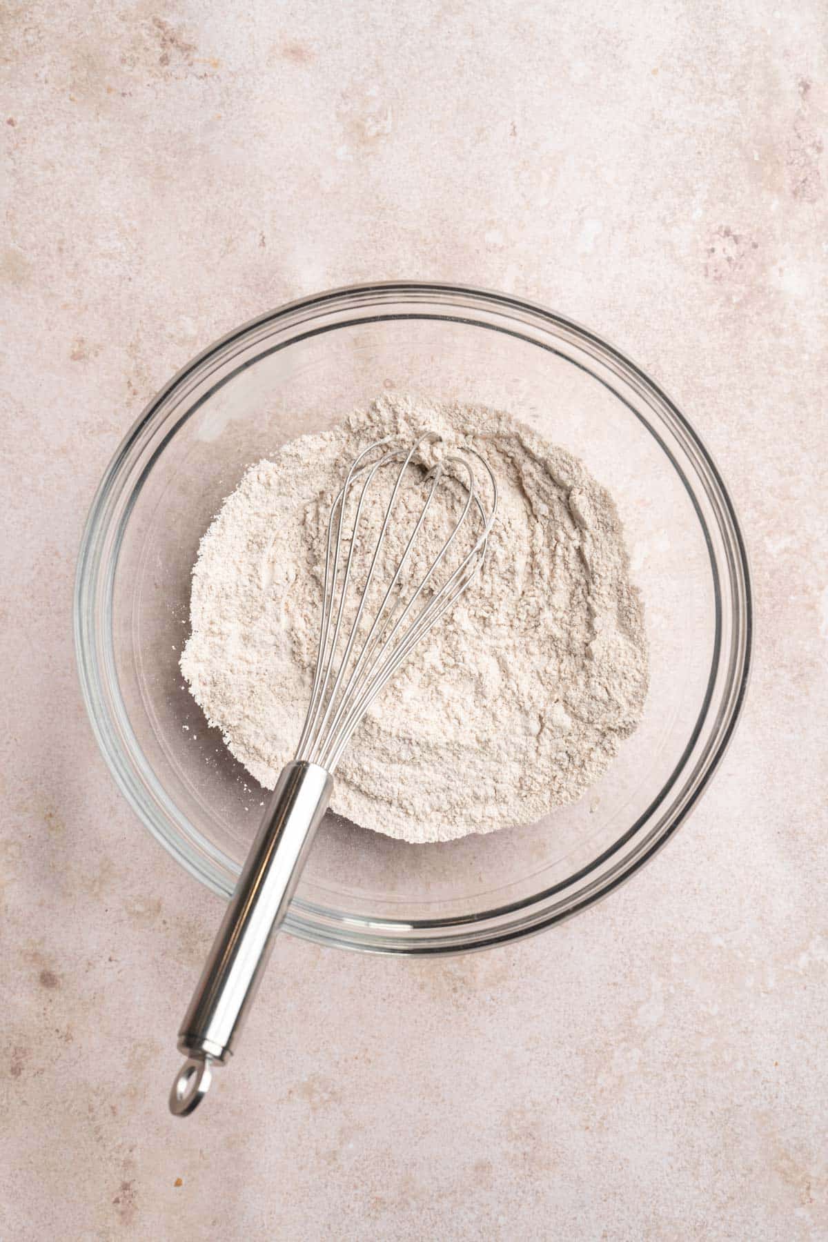 Whisking flour with baking powder and baking soda.