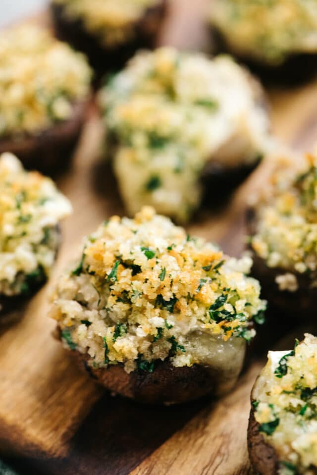 brie stuffed mushrooms on a wooden serving plate