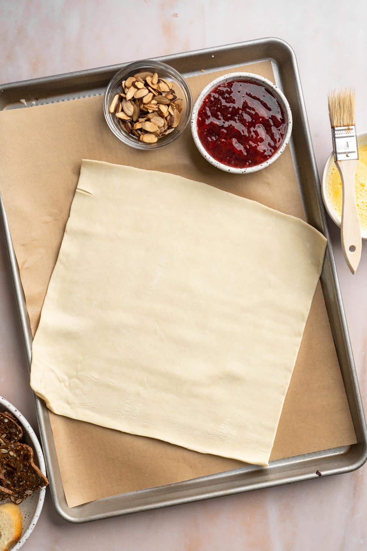 Puff pastry spread on a parchment lined baking pan.