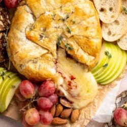 Baked Brie in puff pastry served with grapes, almonds and crackers.