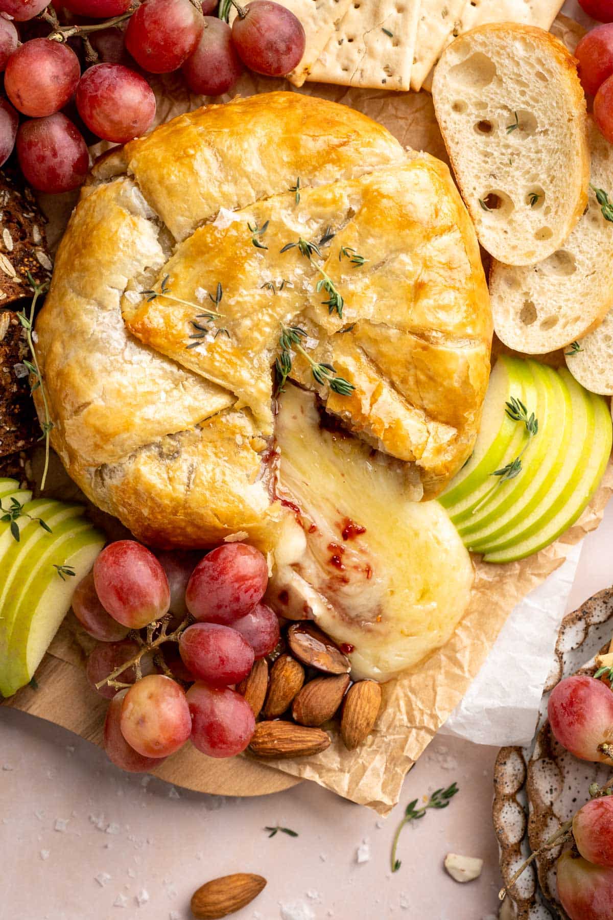 Baked Brie in puff pastry served with grapes, almonds and crackers.